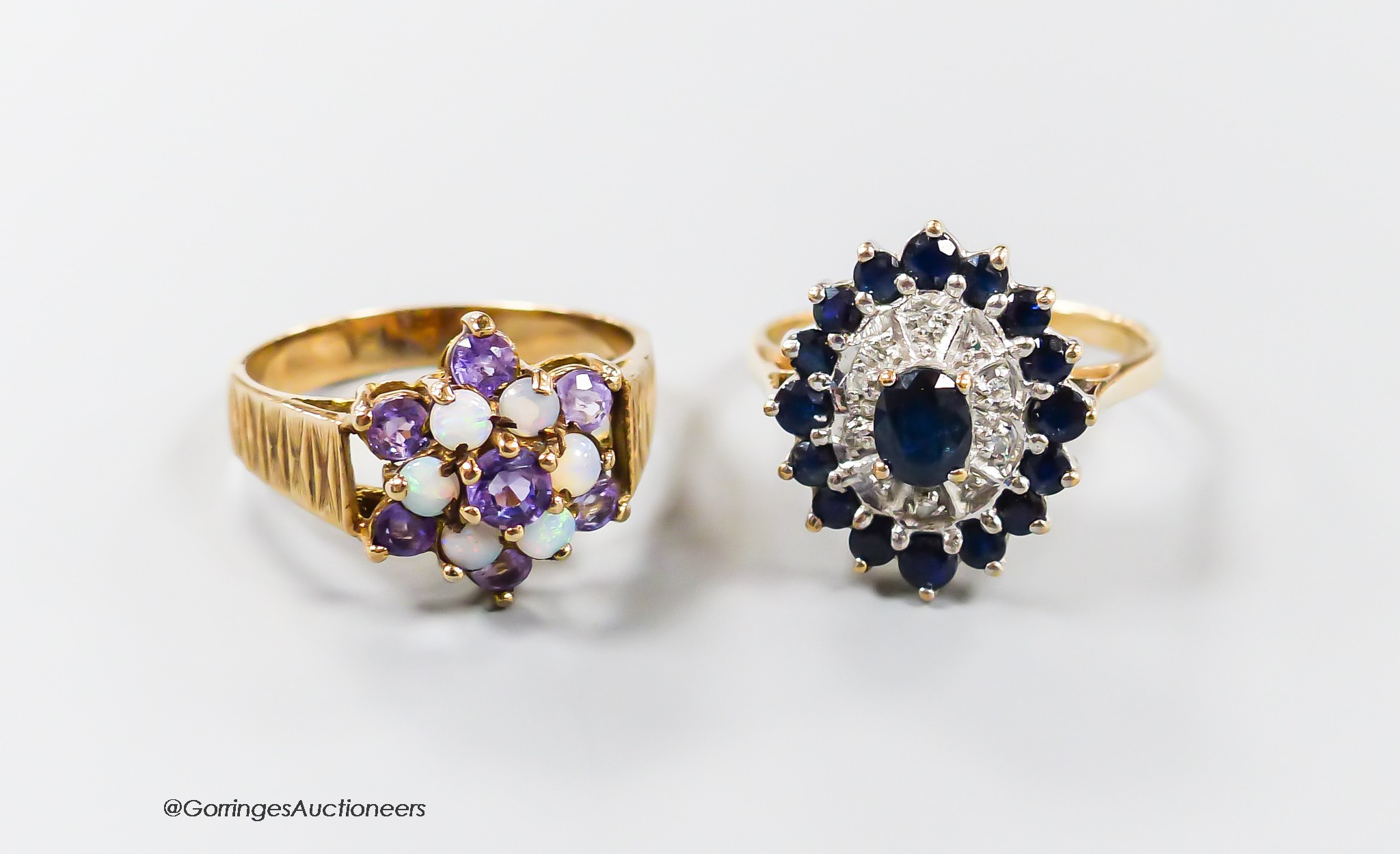 A yellow metal sapphire and diamond chip set oval cluster ring, size P/Q, gross 3.5 grams and a modern textured 9ct gold amethyst and white opal cluster set dress ring, size O/P, gross 3.7 grams.